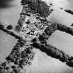 Oblique aerial view centred on the country house with the stables adjacent, taken from the WNW.