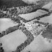 Oblique aerial view centred on the country house with the stables adjacent, taken from the S.