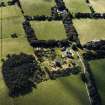 Oblique aerial view centred on the country house with the stables and farmsteading adjacent, taken from the ENE.