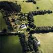 Oblique aerial view centred on the country house with the stables adjacent, taken from the NW.