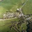 Oblique aerial view of Eddleston centred on the church and churchyard, taken from the WNW.
