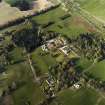 Oblique aerial view centred on the country house, stables and walled garden with the gate-lodge adjacent, taken from the SW.