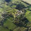 Oblique aerial view centred on the country house, stables and walled garden with the gate-lodge adjacent, taken from the ESE.