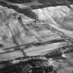 General oblique aerial view centred on the farmhouse and farmsteading with the remains of the scooped settlement adjacent, taken from the NNW