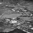 Oblique aerial view from SSE, centred on hangars and various other buildings.