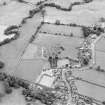 Oblique aerial view of New Abbey centred on the abbey with the abbey wall adjacent, taken from the WNW.