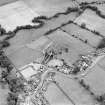 Oblique aerial view of New Abbey centred on the abbey with the abbey wall adjacent, taken from the WSW.