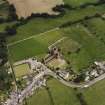 Oblique aerial view of New Abbey centred on the abbey with the abbey wall adjacent, taken from the SW.