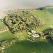 Oblique aerial view centred on the country house, stables, gardens and walled garden, taken from the NW.