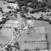 Oblique aerial view of New Abbey centred on the abbey with the abbey wall adjacent, taken from the ESE.