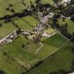 Oblique aerial view of New Abbey centred on the abbey with the abbey wall adjacent, taken from the ENE.