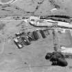 Oblique aerial view centred on Unit 2 of the explosives works and armament depot, showing the former canteen and gun cotton laoding station with five production houses, air-raid shelters and an observation tower, taken from the NNW.
