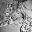 Oblique aerial view of Kirkgunzeon centred on the church, churchyard, manse and road bridge, taken from the SE.