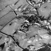 Oblique aerial view centred on the church, burial ground, manse and farmstead with smithy adjacent, taken from the SSE.