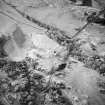 Oblique aerial view centred on the remains of the tower-house, possible garden, buildings and rig, taken from the ENE.