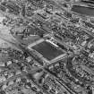 Oblique aerial view of Methil centred on East Fife football ground with Aberhill Primary School adjacent, taken from the W.