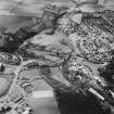 Oblique aerial view of Leslie centred on the village housing development designed by Wheeler and Sproson in 1952-56 with a railway viaduct adjacent, and recorded as part of the Wheeler and Sproson Project.  Taken from the ENE.