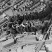 Oblique aerial view centred on the villa with villa and works adjacent, taken from the SE.