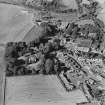 Oblique aerial view centred on the village of Auchtertool with house adjacent, taken from the SE.