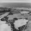 Oblique aerial view looking across house, walled garden, farmsteading and farmhouse towards Kirkcaldy, taken from the WNW.