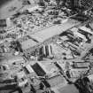Oblique aerial view centred on the site of the works with the whisky distillery, engineering works, foundry and offices and works adjacent, taken from the N.