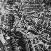 Oblique aerial view centred on the fire station with the works and college adjacent, taken from the NE.
