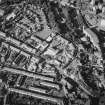 Oblique aerial view centred on the fire station with the works and college adjacent, taken from the WSW.