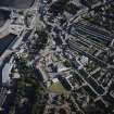 Oblique aerial view centred on the fire station with the works and college adjacent, taken from the N.