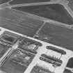 Oblique aerial view of Crail Airfield centred on the remains of the control tower, buildings, huts and aircraft hangars, taken from the WNW.