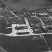 Oblique aerial view of Crail Airfield centred on the remains of the control tower, buildings, huts and aircraft hangars, taken from the SSE.