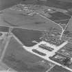 Oblique aerial view of Crail Airfield centred on the remains of the control tower, buildings, huts and aircraft hangars, taken from the ESE.