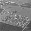 Oblique aerial view of Crail Airfield centred on the remains of buildings, a water tank and a hut, taken from the WNW.