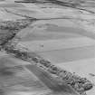 Oblique aerial view of Dunino Airfield centred on the remains of buildings and a control tower, taken from the ENE.