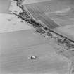 Oblique aerial view of Dunino Airfield centred on the remains of buildings and the control tower, taken from the WNW.