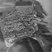 Oblique aerial view of St Monance centred on the village, harbour, church and burial ground, taken from the WSW.