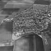 Oblique aerial view of St Monance centred on the village, harbour, church and burial ground, taken from the SW.