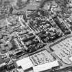 Oblique aerial view centred on the hospital, obelisk, factory and mill, taken from the E.