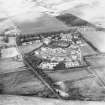 Oblique aerial view centred on the hospital with the farmhouse and farmsteading adjacent, taken from the SSW.