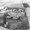 Oblique aerial view centred on the hospital with the farmhouse and farmsteading adjacent, taken from the SW.