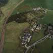 Oblique aerial view of the village centred on the burial-ground, manse and the remains of the church with the farmsteading adjacent, taken from the WSW.