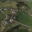 Oblique aerial view of the village centred on the burial-ground, manse and the remains of the church with the farmsteading adjacent, taken from the S.