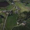 Oblique aerial view of the village centred on the burial-ground, manse and the remains of the church with the farmsteading adjacent, taken from the ESE.