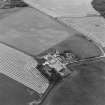 Oblique aerial view of Blervie Castle centred on the remains of a castle or tower-house with attached and adjacent farm buildings, taken from the E.