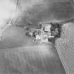 Oblique aerial view of Blervie Castle centred on the remains of a castle or tower-house with attached and adjacent farm buildings, taken from the SW.