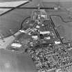 Oblique aerial view of part of Wick Airport, (formerly RAF Wick), taken from the SW. Visible are the two remaining World War Two type 'C' hangars and the present airport terminal buildings.  Also visble is the Caithness Glass Factory and Visitor Centre.
