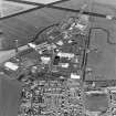 Oblique aerial view of part of Wick Airport, (formerly RAF Wick), taken from the S. Visible are the two remaining World War Two type 'C' hangars and the present airport terminal buildings.  Also visible is the Caithness Glass Factory and Visitor Centre.