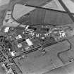 Oblique aerial view of part of Wick Airport, (formerly RAF Wick), taken from the S. Visible are the two remaining World War Two type 'C' hangars and the present airport terminal buildings.  Also visible is the Caithness Glass Factory and Visitor Centre.