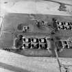 Oblique aerial view centred on the remains of the bomb store, taken from the SW.