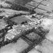 Oblique aerial view centred on the hospital and churches, with the farmsteading adjacent, taken from the SE.