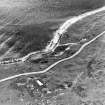 Aerial view of Nigg Second World War coast battery from the N. Two partly demolished gun-emplacements are visible.  The gun-emplacements have been built into the remains of Dunskeath Castle.